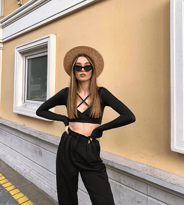 chica de cabello largo usando un crop top blanco, negro, beige, café, verde, azul de manga larga, corta, con jeans ajustados, pantalones negros de cuero, bolso pequeño de mano
