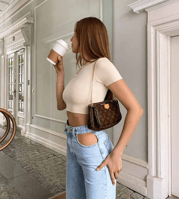chica de cabello largo usando un crop top blanco, negro, beige, café, verde, azul de manga larga, corta, con jeans ajustados, pantalones negros de cuero, bolso pequeño de mano