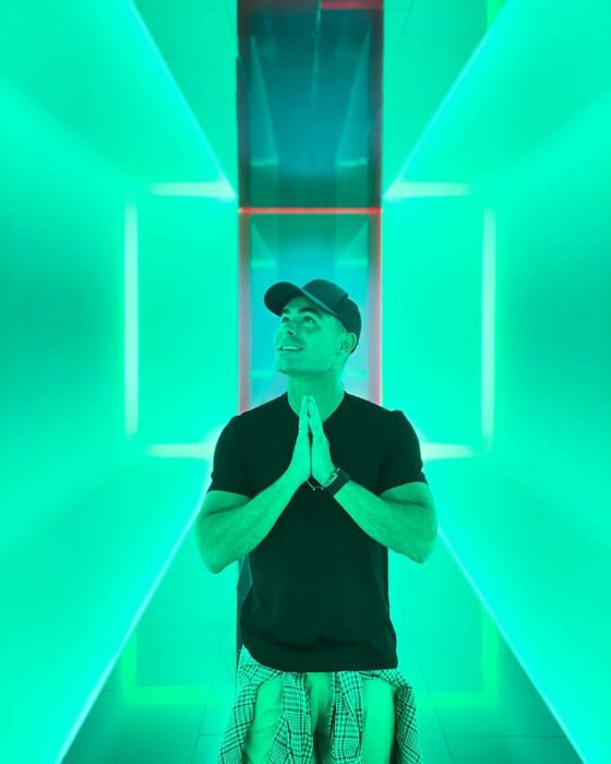 Zac Efron posando para una fotografía en un cuarto verde