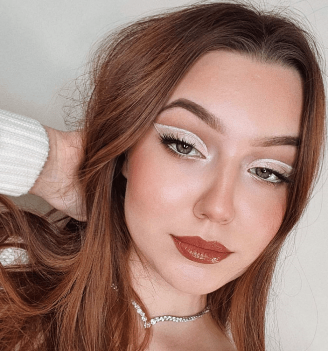 chica de cabello largo castaño claro con maquillaje de sombras rosas, azules, moradas, naranjas, amarillas, negras, oscuras, delineado gráfico, lipstick nude, rojo, rosa, glitter,