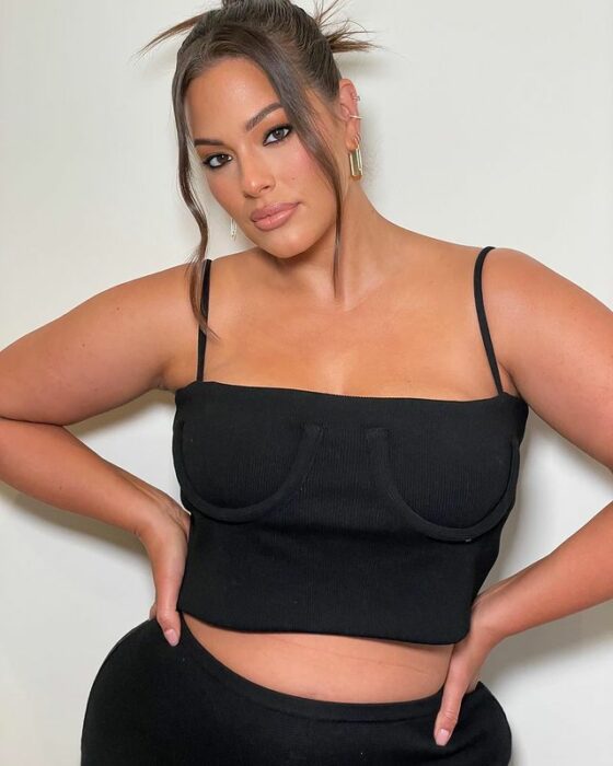 Ashley Graham posando para una sesión de fotos en un outfit negro