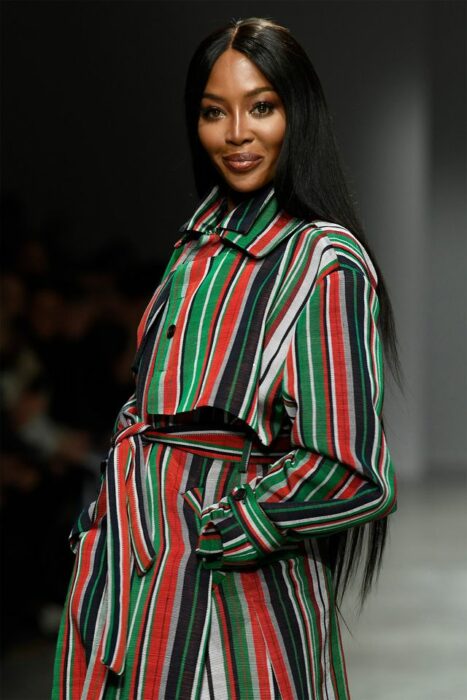 Naomi Campbell caminando por la pasarela mientras usa un vestido de colores