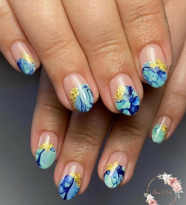 Chica con unas uñas estilo mármol con diferentes colores