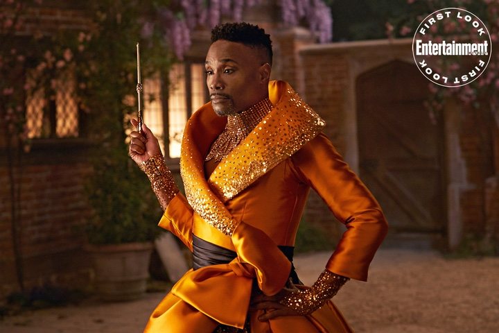 Billy Porter usando un traje de color naranja para ser la nueva hada madrina de Cenicienta