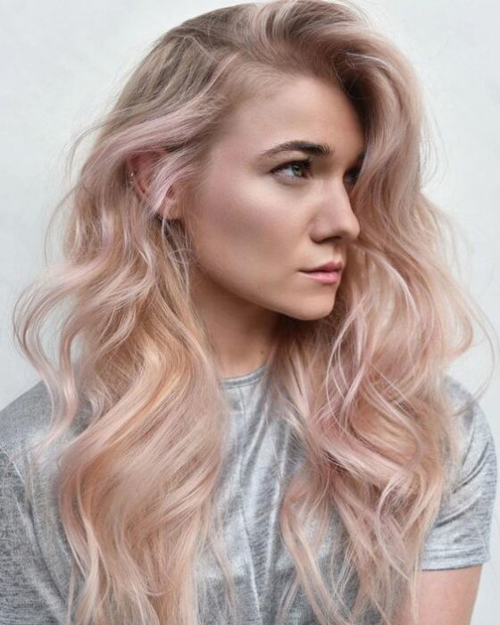 chica de perfil mostrando su cabello teñido en rose gold; 14 Pruebas de que el tinte rose blonde es la nueva tendencia