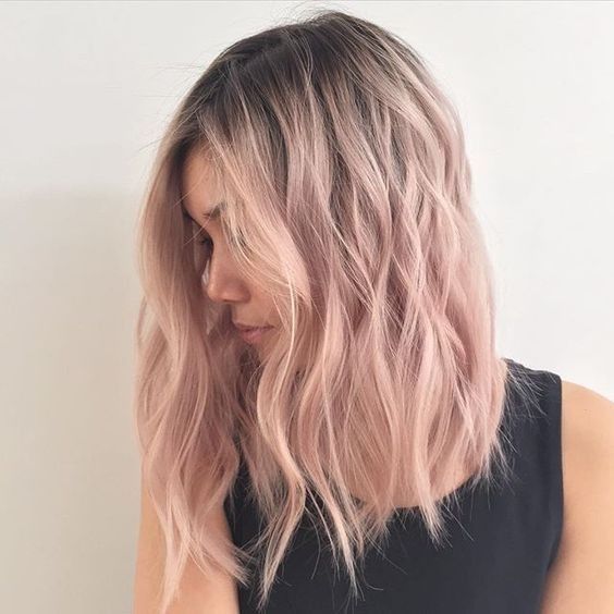 chica con cabello teñido en tono rose gold con raíz oscura; 14 Pruebas de que el tinte rose blonde es la nueva tendencia