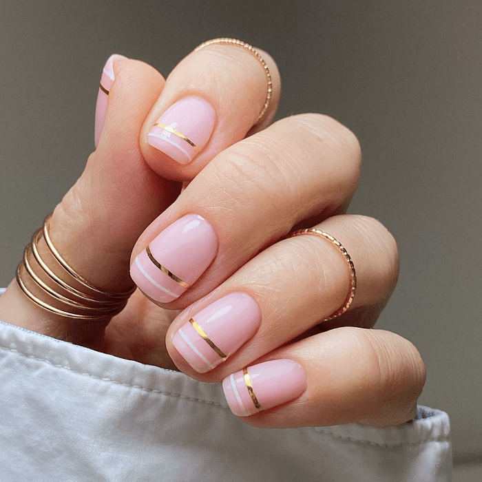 uñas con cinta dorada y esmalte brillante