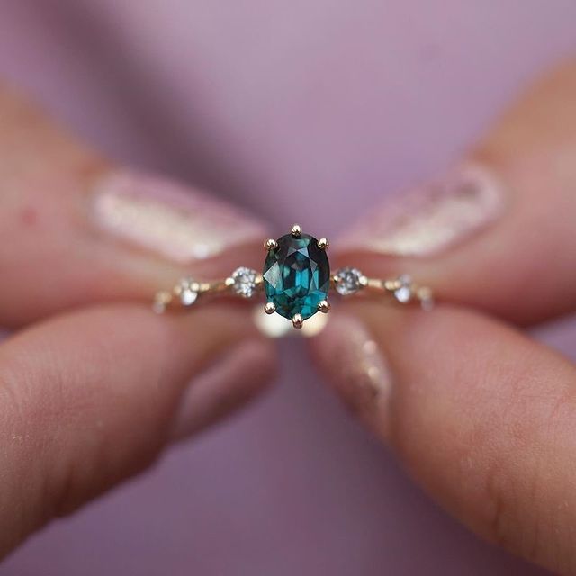 Anillo de compromiso dorado con piedra verde