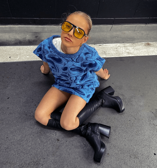 chica de cabello largo usando un outfit sesentero con minifalda, vestido, blusa, crop top, botas de plataforma en colores brillantes