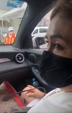 Mamá e hijo en el carro haciendo una fila para vacunarse