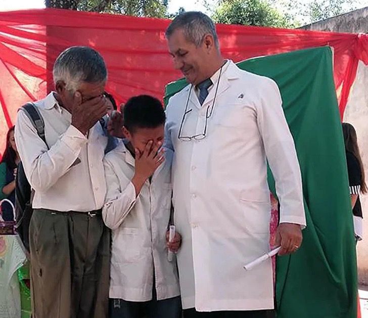 Abuelito y nieto llorando tras recibir su diploma en la escuela; Abuelo y nieto rompen en llanto recibiendo su diploma. Caminaron 6 km a diario hasta la escuela