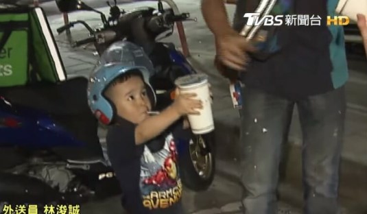 Niño que ayuda a su padre repartidor entregando una bebida