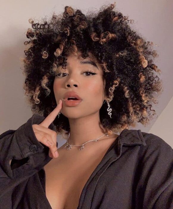 Chica con el cabello rizado y teñido de color naranja