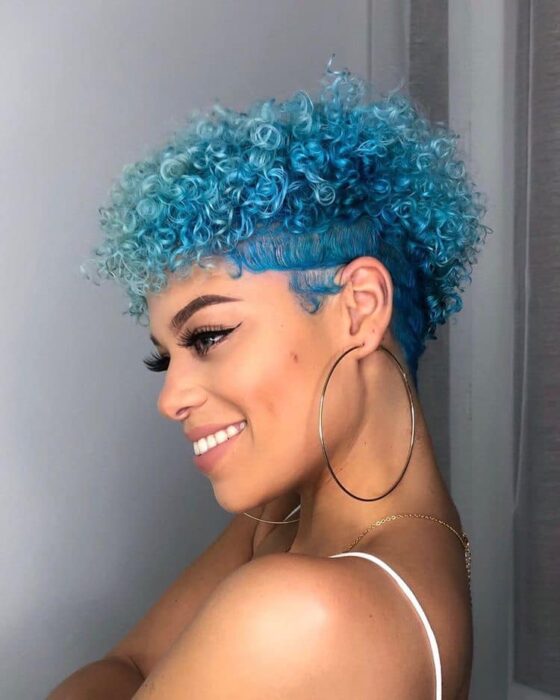 Chica con el cabello rizado y teñido de color azul