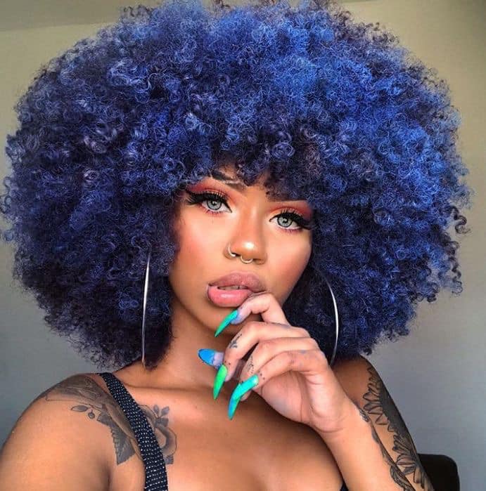 Chica con el cabello rizado y teñido de color morado
