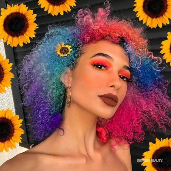 Chica con el cabello rizado y teñido de múltiples colores