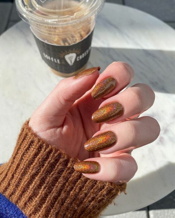 Chica con uñas holográficas en tonos cafés