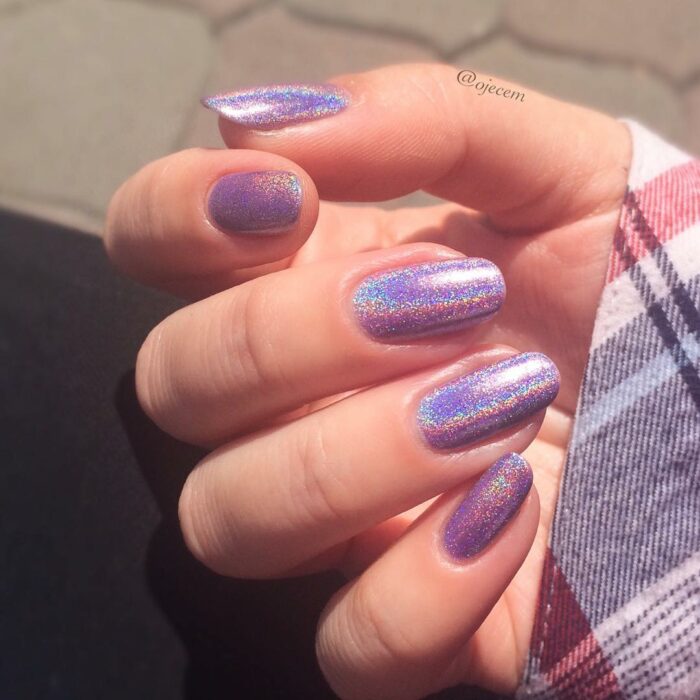 Chica con uñas holográficas en tonos rosados