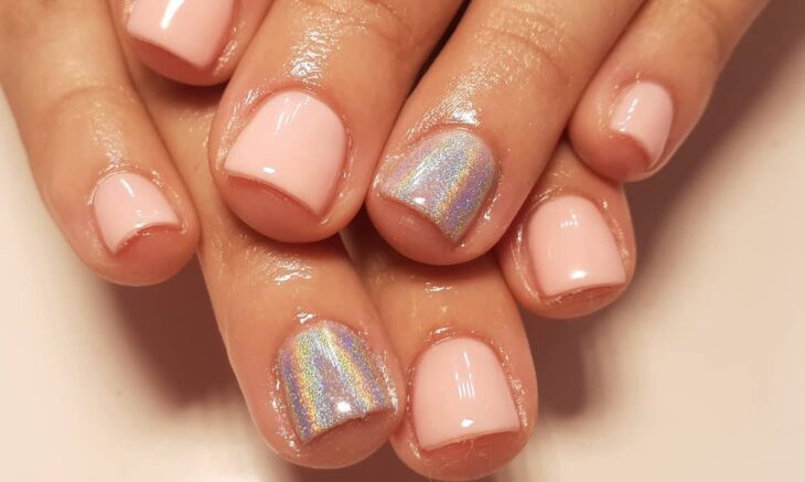 Chica con uñas holográficas en tonos plateados