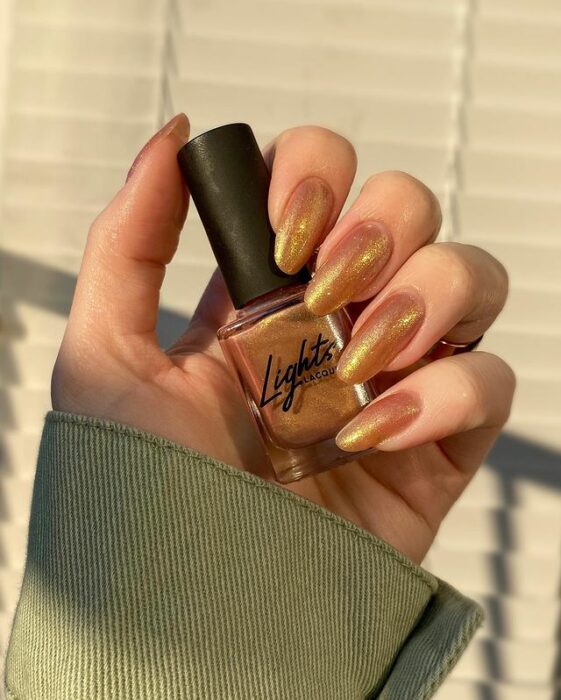 Chica con uñas holográficas en tonos cafés
