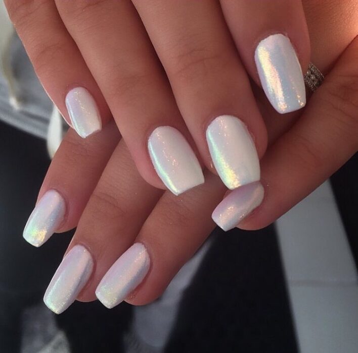 Chica con uñas holográficas en tonos rosados con blanco