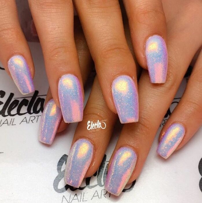 Chica con uñas holográficas en tonos rosados