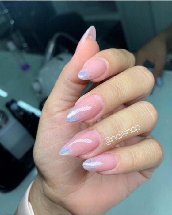 Chica con uñas holográficas en tonos rosados