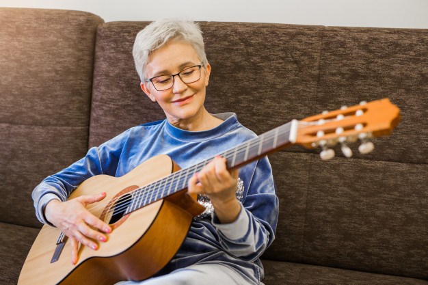 mujer tocando la guitarra ;13 Regalos chulos y originales para sorprender a mamá en su día 