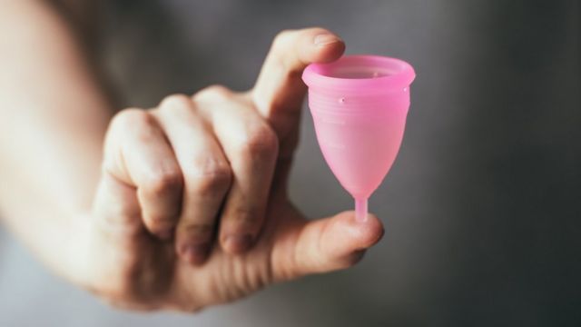 Mujer sosteniendo una copita menstrual