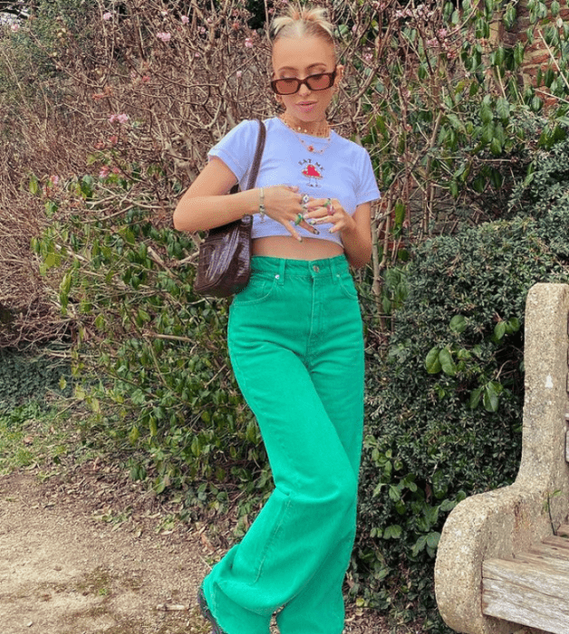 joven rubia con gafas de sol, crop top blanco y pantalones verdes holgados