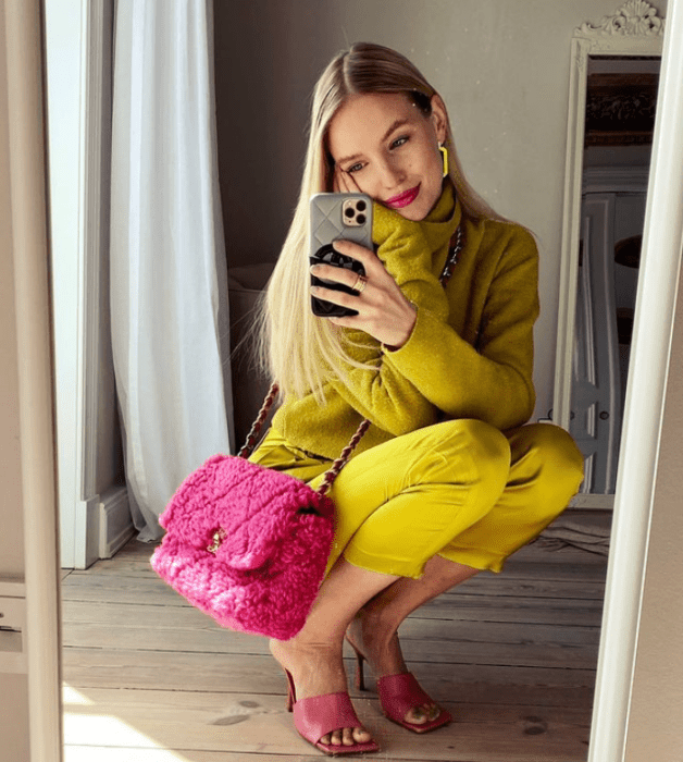joven rubia con traje amarillo mostaza, bolso fucsia y sandalias rosas