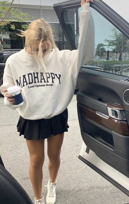 chica con falda plisada y sudadera amplia; 13 Outfits colegiales que extrañas de la escuela