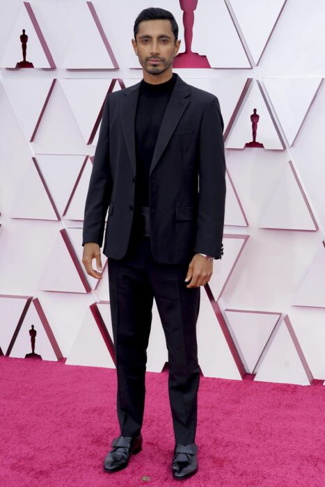 Riz Ahmed en la alfombra roja de los Oscar usando un traje de color negro