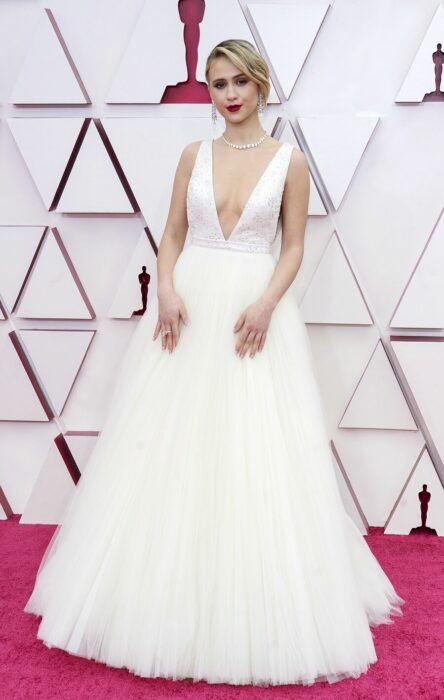 Maria Bakalova en la alfombra roja de los Oscar usando un vestido de color blanco