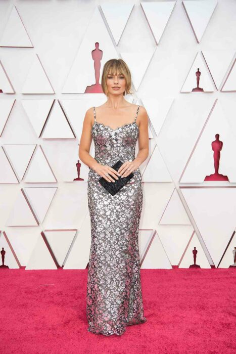 Margot Robbie en la alfombra roja de los Oscar usando un vestido de color plateado