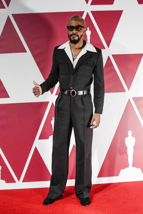 Lakeith Stanfield usando un mono de color negro con una camisa blanca