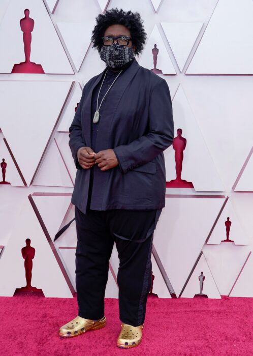 Questlove usando un atuendo negro con crocs doradas en la entrega de premios Oscar 2021