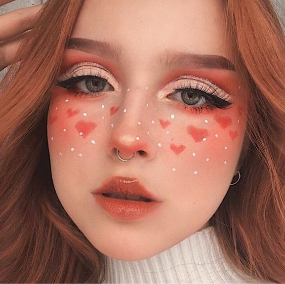 Chica con maquillaje en tono rojo con forma de corazón; 13 Maquillajes aesthetic para presumir en tu IG