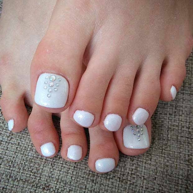Diseño de uñas para pies en color blanco con pedrería