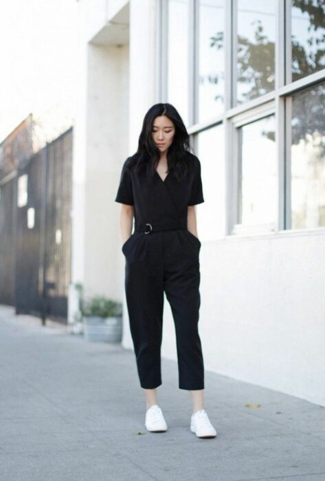 Chica usando un jumpsuit de color negro con tenis blancos