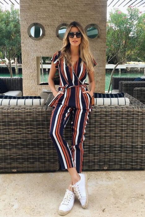 Chica usando un jumpsuit de rayas con tenis blancos