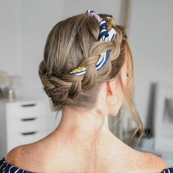 Chica con el cabello hasta los hombros sujetados con una trenza y una bandana