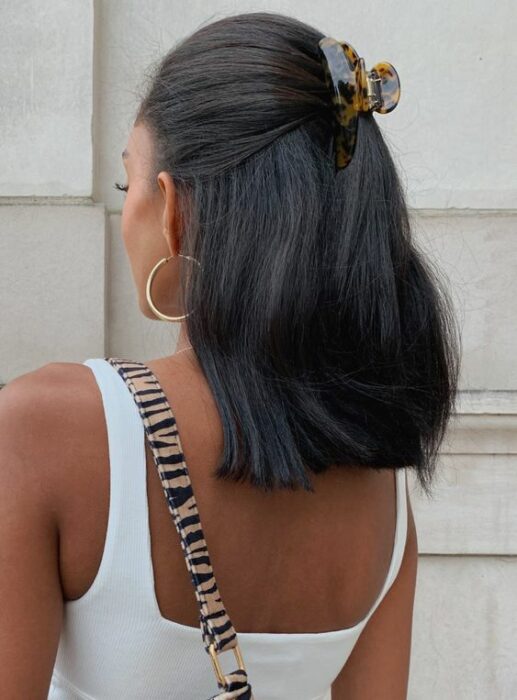 Chica con el cabello hasta los hombros sujetado con una pinza animal print