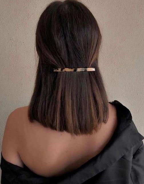 Chica con el cabello hasta los hombros sujetado con un pasador largo