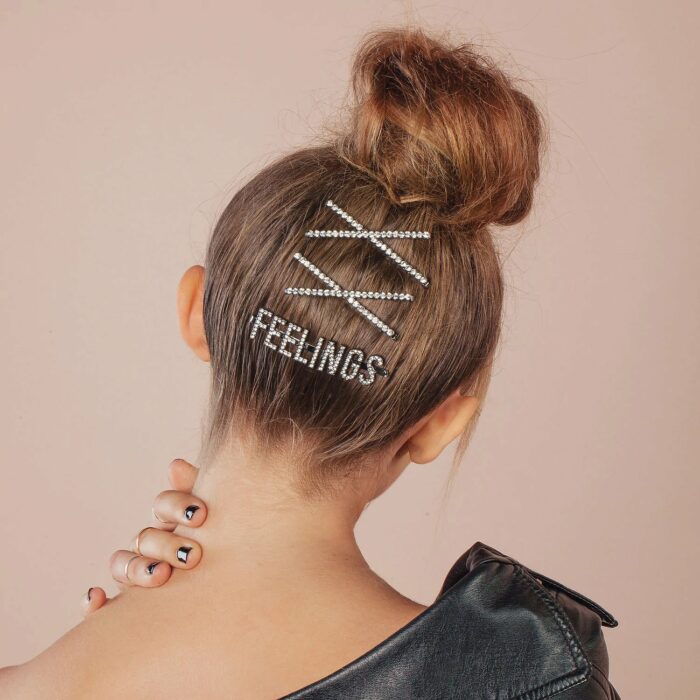 Chica con el cabello hasta los hombros sujetado con varios pasadores