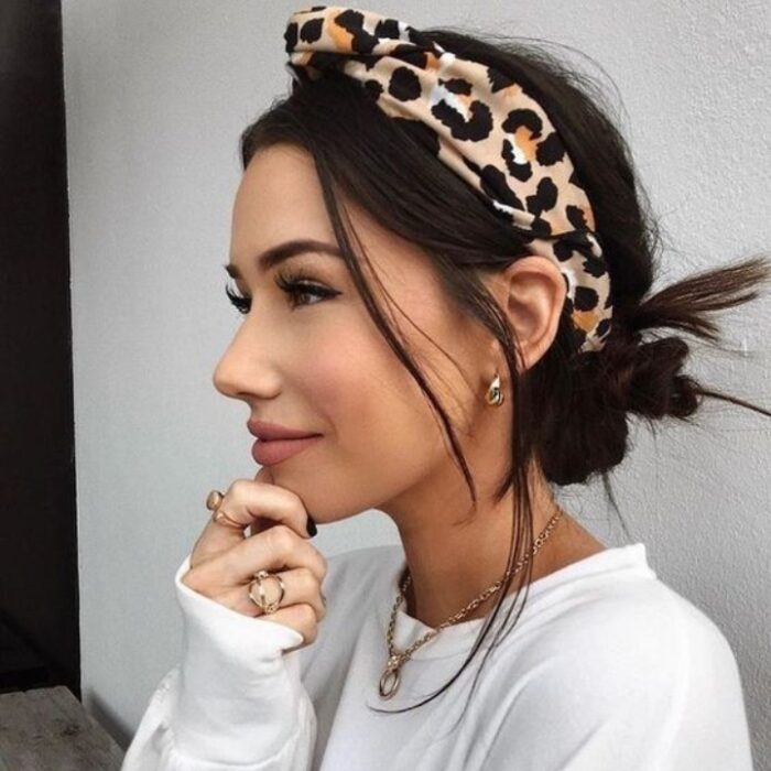 Chica con el cabello hasta los hombros sujetado con una diadema y un moño bajo