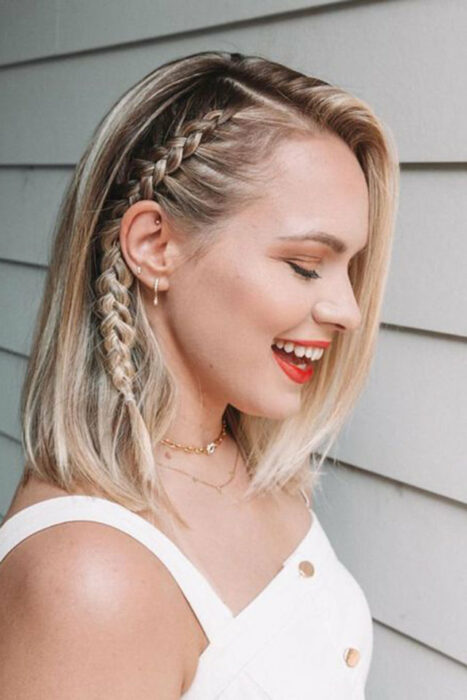 Chica con el cabello hasta los hombros sujetado con una trenza lateral