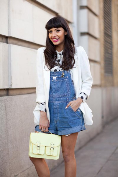 Chica usando un overol con una blusa de color blanco y negro, y un saco blanco