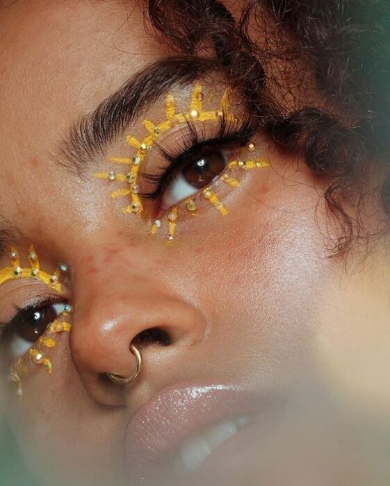 Chica con delineado amarillo en forma de sol con piedras; Maquillaje de primavera que amarás