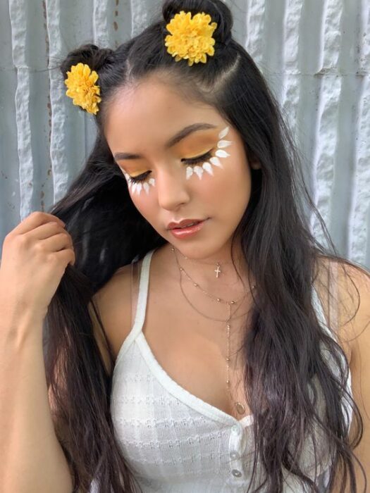 Chica mirando hacia abajo con maquillaje en forma de margarita en los ojos; Maquillaje de primavera que amarás
